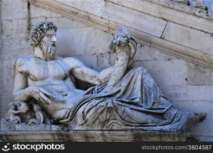 Ancient statue of the Tiber river god in front of the Senatorial Palace staircase on the Capitoline Hill in Rome, Italy