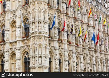 Ancient stone building facade with big windows, old Europe. European architecture, medieval town, famous places for tourism and travel. Ancient building facade with big windows, Europe