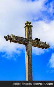 Ancient stone Catholic crucifix covered by parasitic plants and moss built in the late 17th century when the city of Lavras Novas in Minas Gerais appeared. Ancient stone Catholic crucifix covered by parasitic plants and moss
