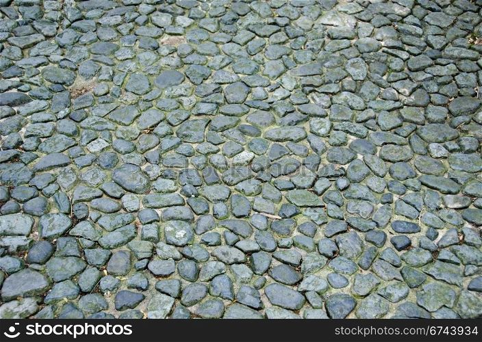 Ancient street background. Ancient street made of cobblestones, cobbles, background pattern