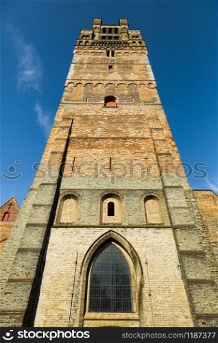 Ancient tower in provincial European town, bottom view. Summer tourism and travels, famous europe landmark, popular places for vacation tour or holidays