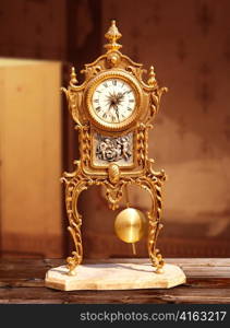 ancient vintage brass pendulum clock in old house interior