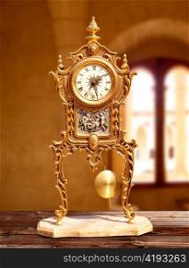 ancient vintage brass pendulum clock in old house interior