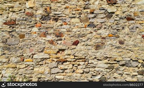 Ancient wall with stones, cobblestones and bricks. Close-up texture.