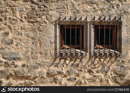 ancient windows of a medieval building with bars