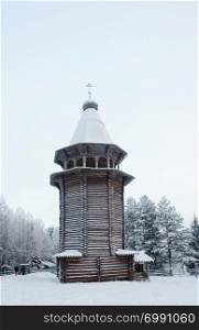 Ancient wooden bell tower (16th century) in the northern open air museum Malye Korely near Arkhanglesk, Russia. Winter snowy day.