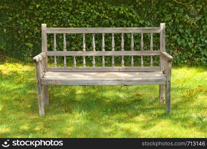 Ancient wooden bench in a garden on a sunny day. Ancient wooden bench in a garden