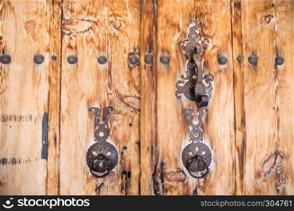 Ancient wooden door with two traditional old rustic door knocker rings in Kemaliye,Egin,Turkey. Ancient wooden door with door knocker rings