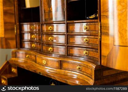 Ancient wooden dresser with many drawers in museum, Europe, nobody. Old european architecture and style, famous places for travel and tourism