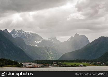 Andalsnes and mountains along the Romsdalsfjorden under a cloudy sky, Norway. Along the Romsdalsfjorden near Andalsnes, Norway
