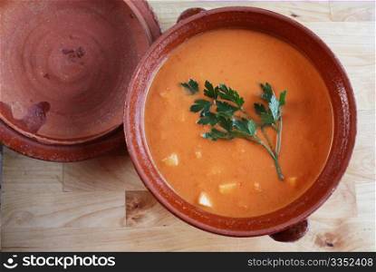 Andalusian gazpacho in a clay pot. It is a cold Spanish tomato-based raw vegetable soup and consumed during summer months due to its refresing qualities.