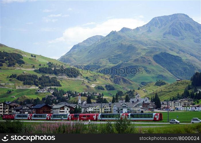 ANDERMATT, SWITZERLAND - CIRCA AUGUST 2015 Train and town near mountain