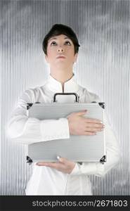 androgynous businesswoman holding silver briefcase over gray background