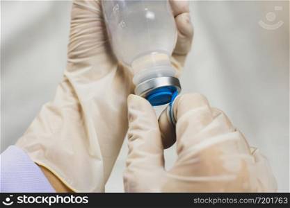 Anesthesiologist Doctors hand is opening normal saline solution (NSS) bottle,Coronavirus treatment concept,Covid-19.