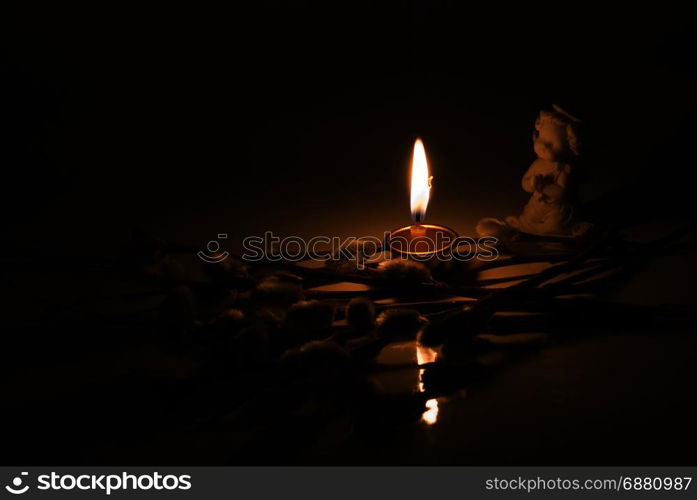 Angel, burning candle and willow twigs