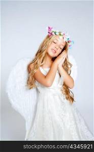 Angel children blond girl with sleeping hands gesture and fashion crown
