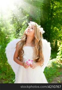 Angel children girl in forest with flower in hand looking sky light beams