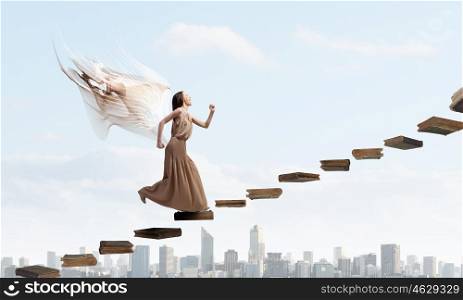 Angel girl in dress. Attractive woman running with angel wings behind back