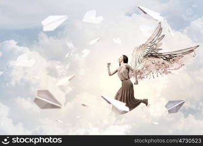 Angel girl in dress. Attractive woman running with angel wings behind back