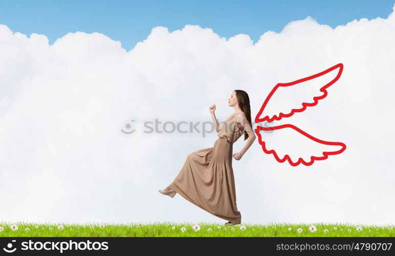 Angel girl in dress. Attractive woman running with angel wings behind back