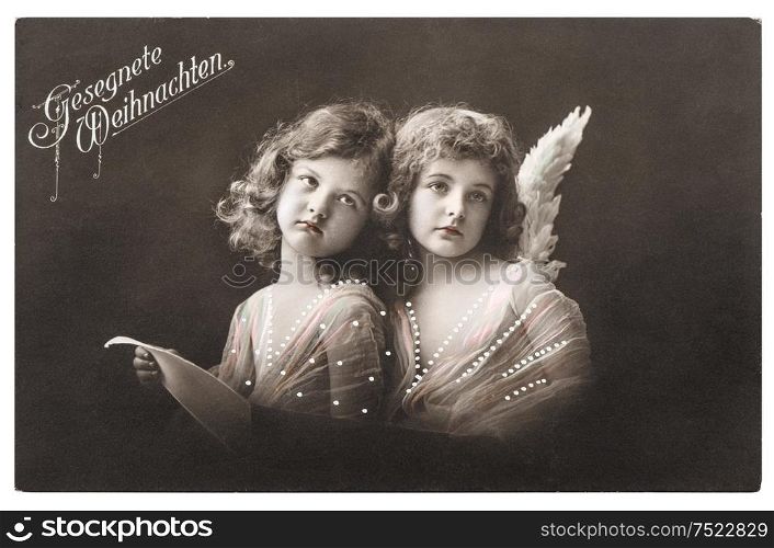 Angel girls with white wings. Christmas greetings card. Vintage picture with original film grain and blur, 1912