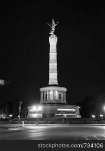 Angel statue aka Siegessaeule (meaning Victory Column) in Tiergarten park in Berlin, Germany at night in black and white. Angel statue in Berlin in black and white