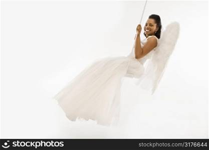 Angelic Mid-adult African-American bride swinging.