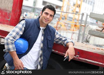 Angled shot of construction worker leaning on a truck