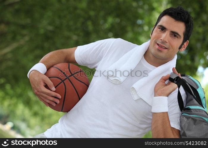Angled shot of man with basketball and kit bag