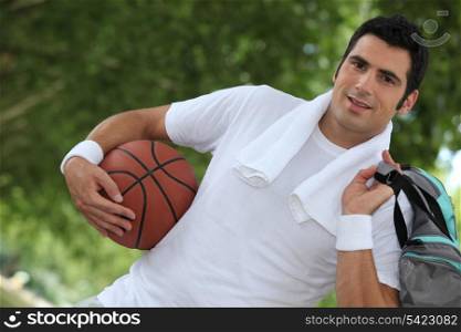 Angled shot of man with basketball and kit bag