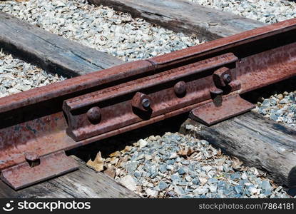 Angled view of rusted railway ties linked with four bolts.