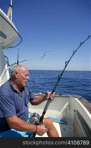 Angler elderly big game sport fishing boat blue summer sea sky