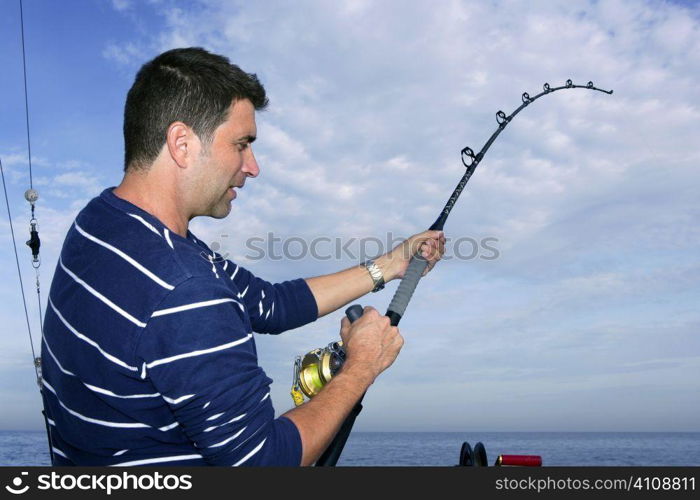 Angler fisherman fighting big fish rod and reel saltwater ocean