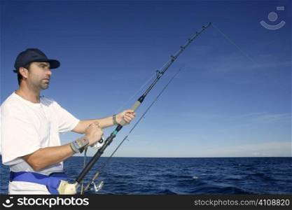 Angler fisherman trolling rod and reel fighting saltwater fish