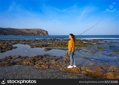 Angler fishing girl in Mediterranean Javea beach. Angler fishing girl with rod in Mediterranean Javea beach at Alicante Spain