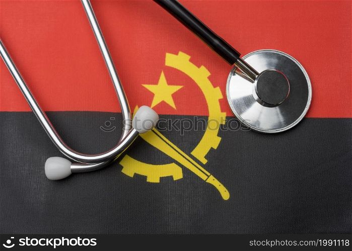 Angola flag and stethoscope. The concept of medicine. Stethoscope on the flag as a background.. Angola flag and stethoscope. The concept of medicine.