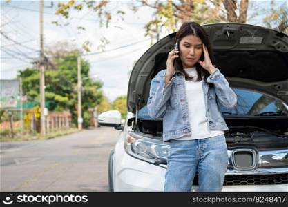 Angry Asian woman and using mobile phone calling for assistance after a car breakdown on street. Concept of vehicle engine problem or accident and emergency help from Professional mechanic