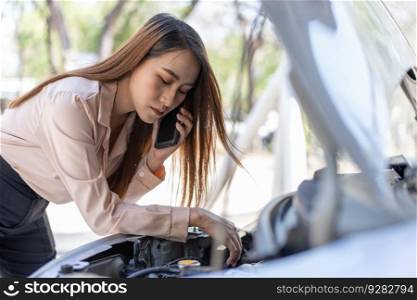Angry Asian woman using a smartphone VIDEO conference for assistance after a car breakdown on street. Concept of a vehicle engine problem or accident and emergency help from a Professional mechanic