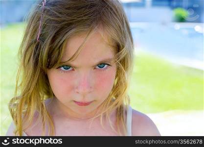 Angry blond children girl portrait looking at camera