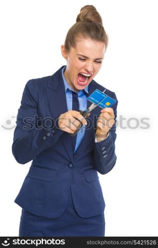 Angry business woman cutting credit card with scissors