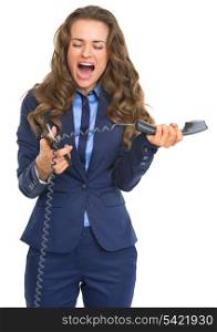 Angry business woman cutting phone handset with scissors