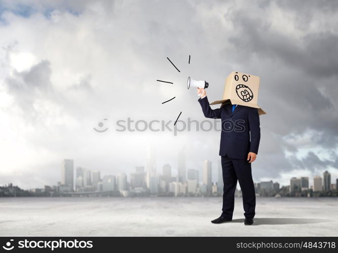 Angry businessman. Businessman wearing carton box on head and screaming in to megaphone