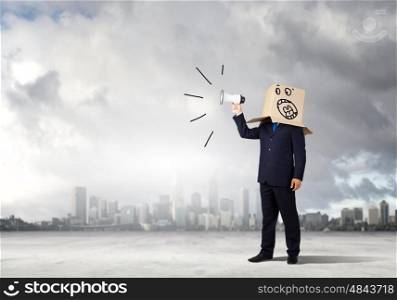 Angry businessman. Businessman wearing carton box on head and screaming in to megaphone