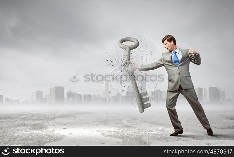 Angry businessman crashing stone key with punch. Determined and powerful