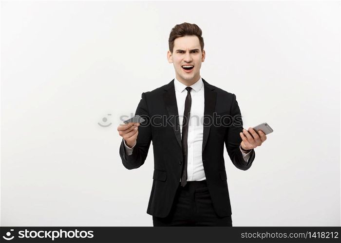 Angry businessman holding credit card and mobile phone. Get Mad while shopping online or business problem. Angry businessman holding credit card and mobile phone. Get Mad while shopping online or business problem.