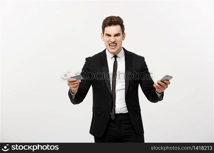 Angry businessman holding credit card and mobile phone. Get Mad while shopping online or business problem. Angry businessman holding credit card and mobile phone. Get Mad while shopping online or business problem.