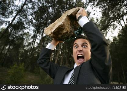 Angry businessman in outdoor forest, big stone in hands