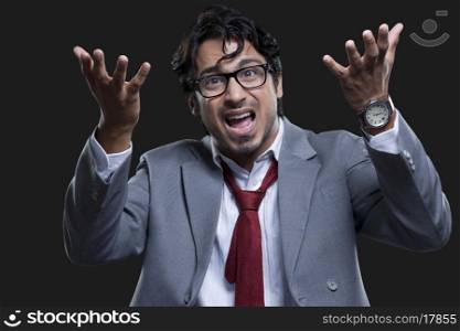 Angry businessman screaming against black background