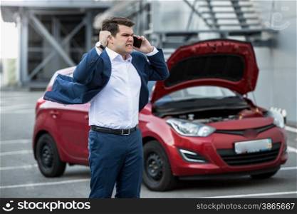 Angry businessman shouting in phone because of broken car