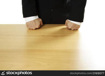 Angry businessman with both fists on the table